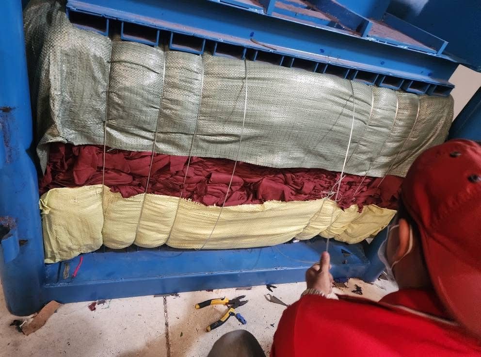 A bale of cuttings being strapped in the hydraulic press